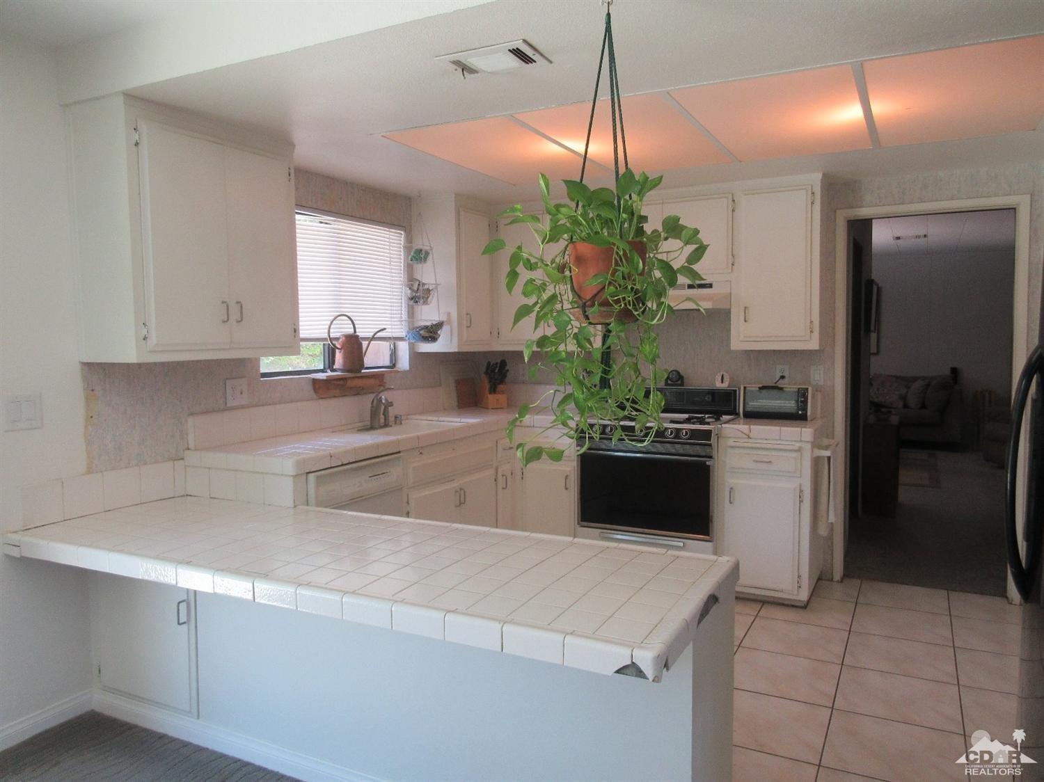 36915 Palmdale Road Rancho Mirage, CA 92270 - Photo 9 of 23 a kitchen with a refrigerator a sink and cabinets