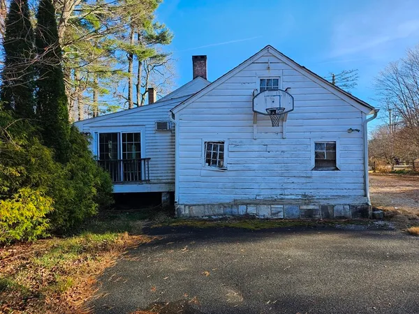 a view of a house with a small yard and a large tree