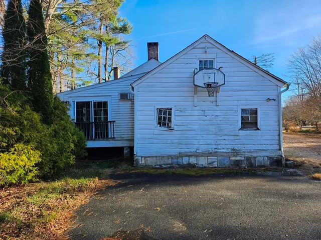 a view of a house with a small yard and a large tree