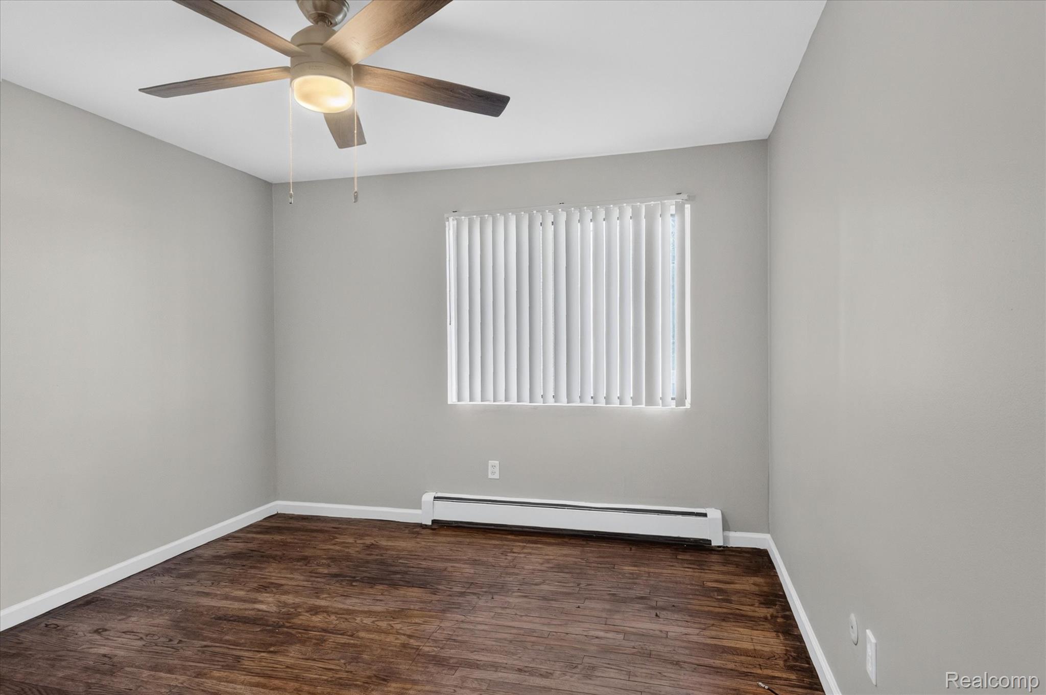 32650 Mound Road, Unit 4 Warren, MI 48092 - Photo 13 of 32 Recessed window with vertical blinds, wood-finish flooring, ceiling fan with integrated lighting, and a white baseboard heater