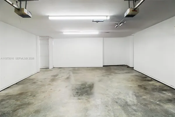 an empty room with projector & cabinets