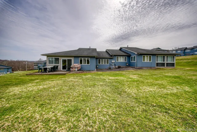 a view of a house with a big yard and large trees