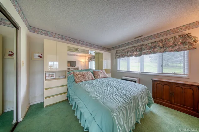 a bedroom with a bed and a large window