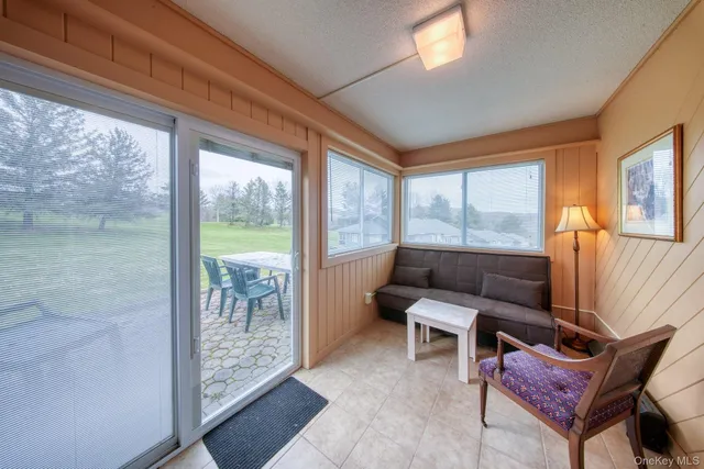a living room with furniture and a floor to ceiling window