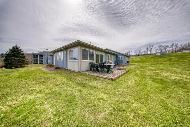 a view of a house with a big yard and large trees