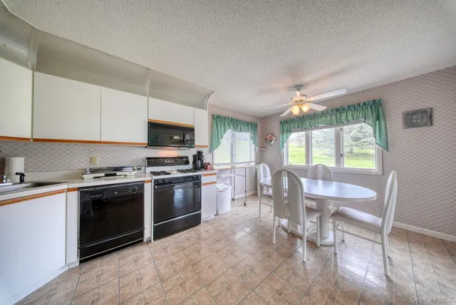 a kitchen with stainless steel appliances granite countertop a stove top oven a sink dishwasher a dining table and chairs with wooden floor