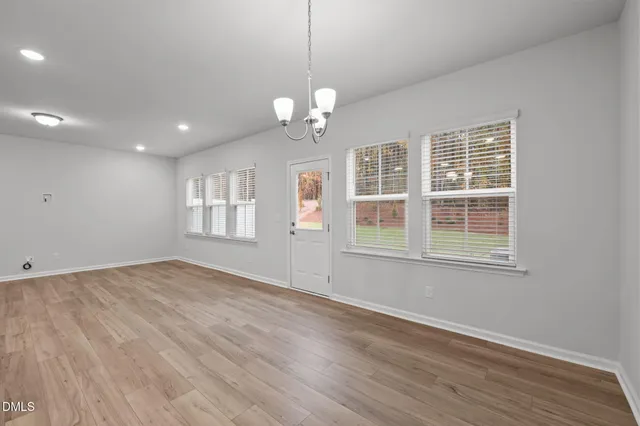 a view of a kitchen with kitchen island a sink wooden floor and stainless steel appliances