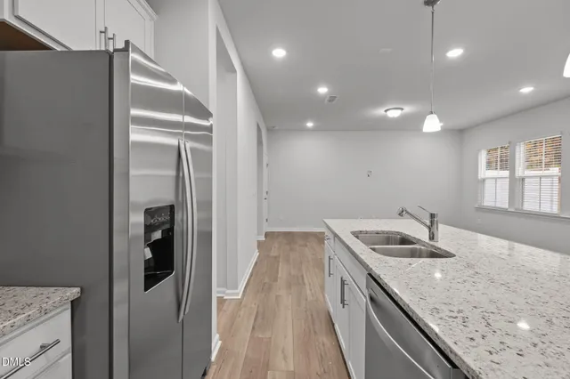 a kitchen with stainless steel appliances granite countertop a sink stove and refrigerator