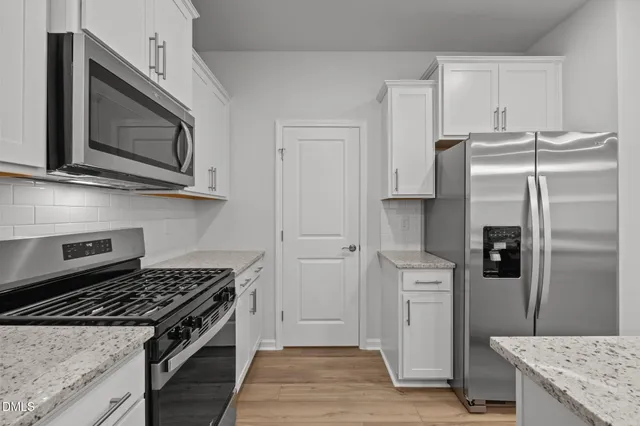 a kitchen with granite countertop a sink and refrigerator