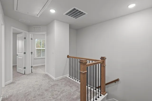 a view of hallway with staircase and white walls