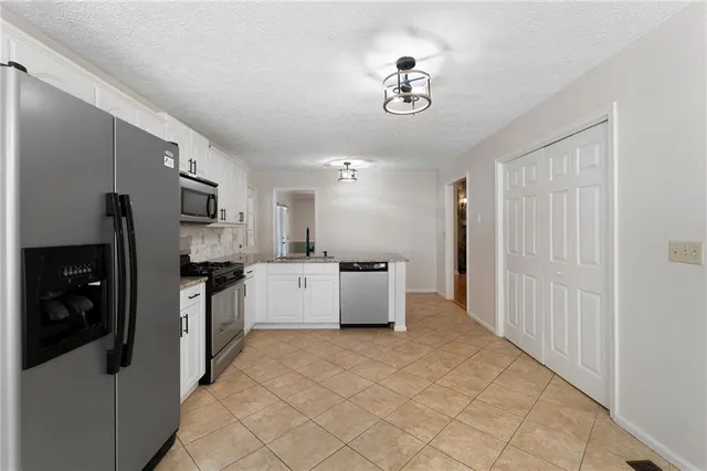 a view of an empty room with window and cabinet