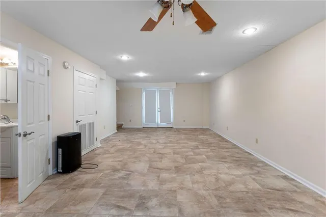 a view of a white house with large trees and outdoor space