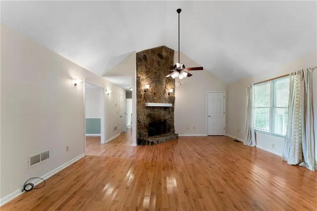 a view of a room with a fireplace wooden floor and windows
