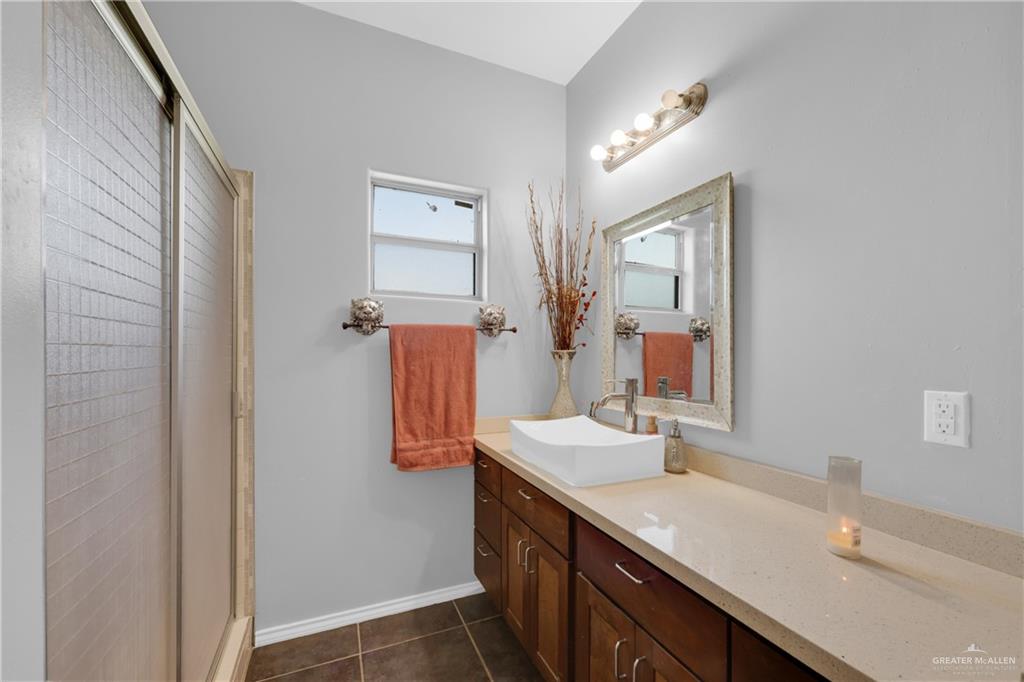 715 North Gonzalez Road Weslaco, TX 78596 - Photo 14 of 31 a bathroom with a double vanity sink a mirror and shower