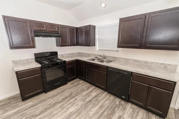 a kitchen with granite countertop stainless steel appliances and wooden cabinets
