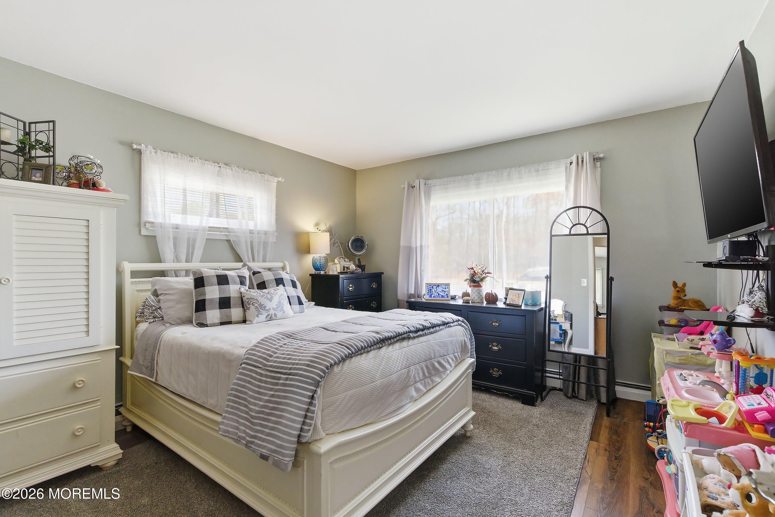 745 Oak Glen Road Howell, NJ 07731 - Photo 16 of 46 a bedroom with a bed and a flat tv screen on the dresser
