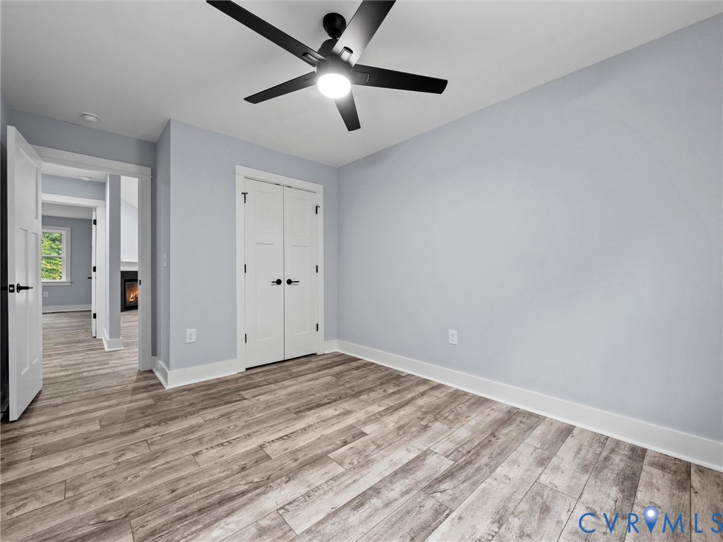 20475 Tabernacle Road Barhamsville, VA 23011 - Photo 13 of 23 an empty room with wooden floor and ceiling fan