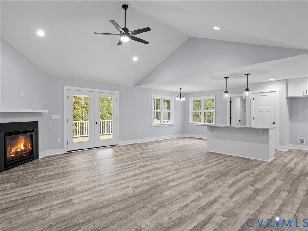 20475 Tabernacle Road Barhamsville, VA 23011 - Photo 5 of 23 an empty room with wooden floor a kitchen view and a window