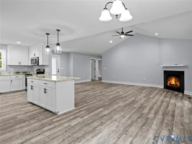 a large kitchen with granite countertop a white stove top oven and cabinets