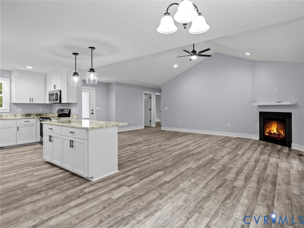 20475 Tabernacle Road Barhamsville, VA 23011 - Photo 6 of 23 a large kitchen with granite countertop a white stove top oven and cabinets