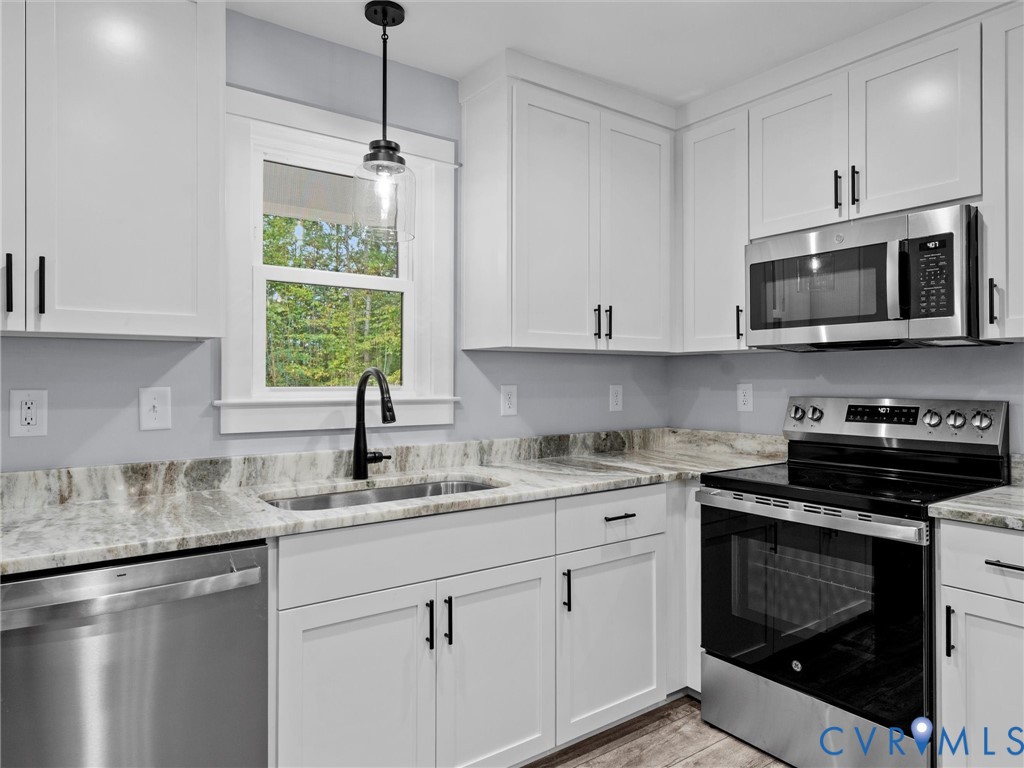 20475 Tabernacle Road Barhamsville, VA 23011 - Photo 9 of 23 a kitchen with stainless steel appliances granite countertop a sink a stove a microwave and wooden cabinets