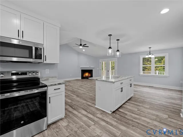 a kitchen with stainless steel appliances white cabinets a stove a sink and a microwave