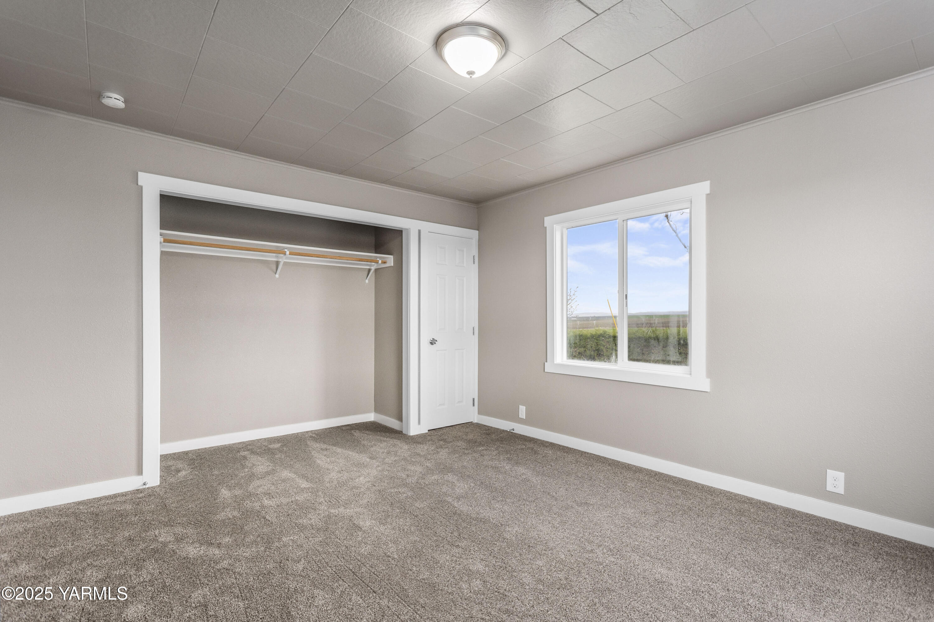 173801 Evans Road Grandview, WA 98930 - Photo 17 of 45 an empty room with a empty space and windows