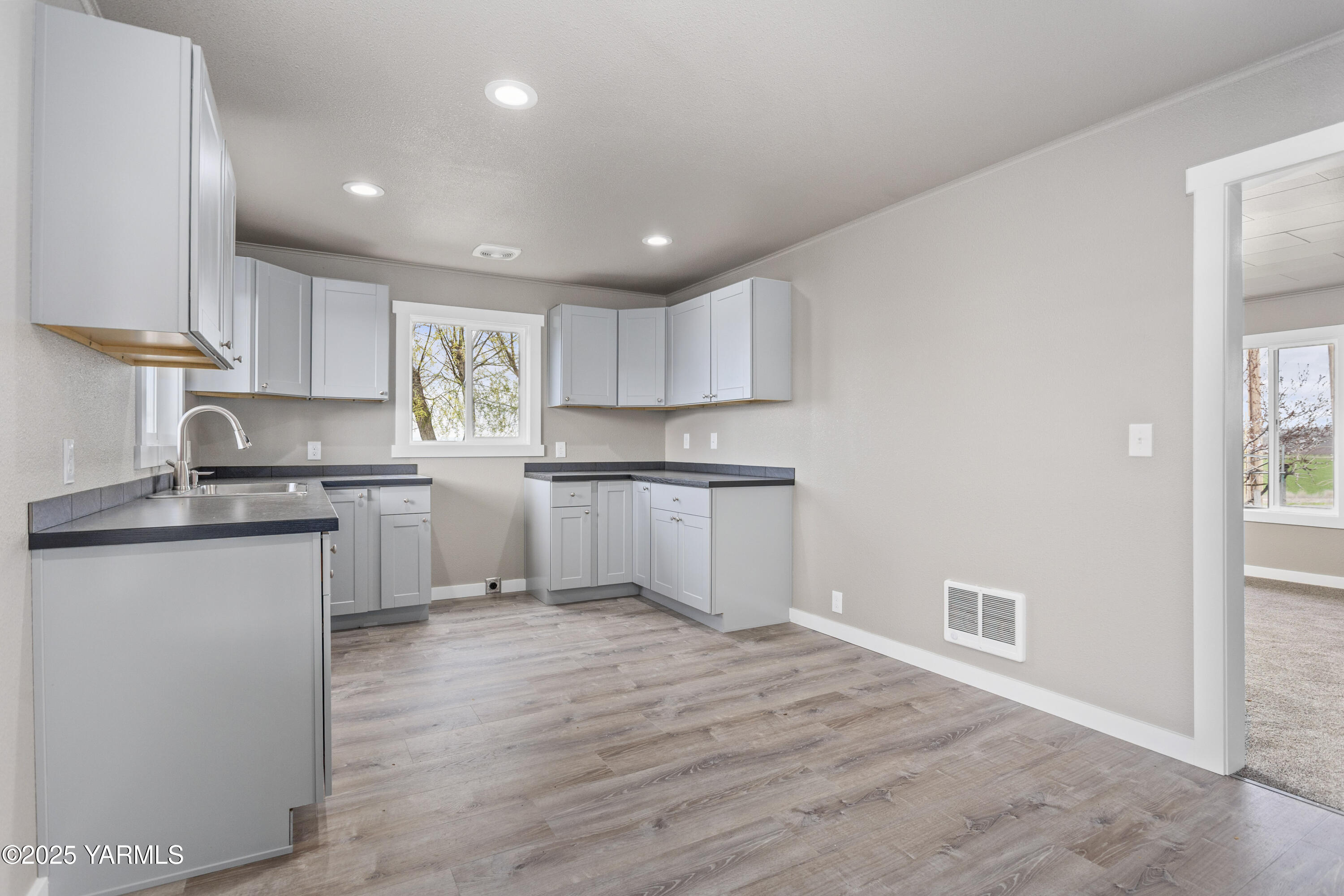 173801 Evans Road Grandview, WA 98930 - Photo 18 of 45 a kitchen with granite countertop white cabinets and white appliances