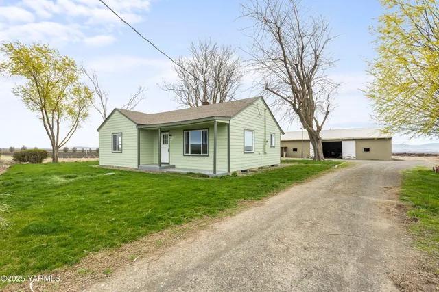 a front view of a house with a garden and trees