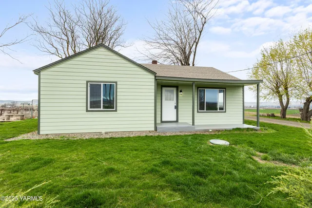 a view of a house with a backyard and a tree