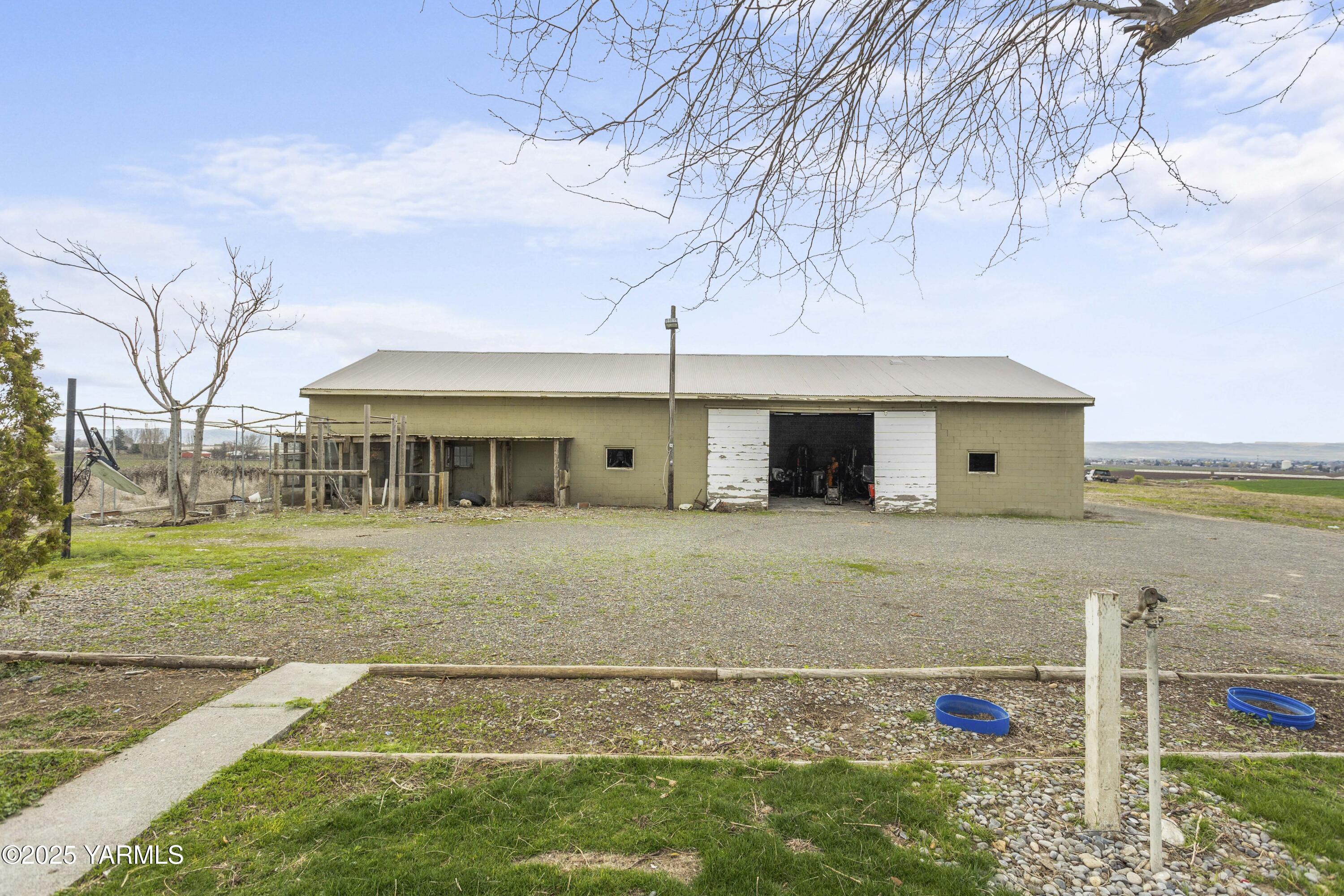 173801 Evans Road Grandview, WA 98930 - Photo 27 of 45 a front view of a house with a garden and yard