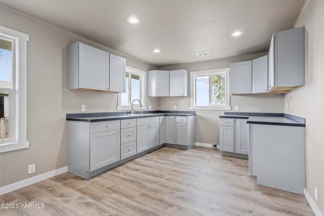 a kitchen with granite countertop white cabinets and white appliances
