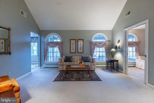 a living room with furniture a mirror and a lamp