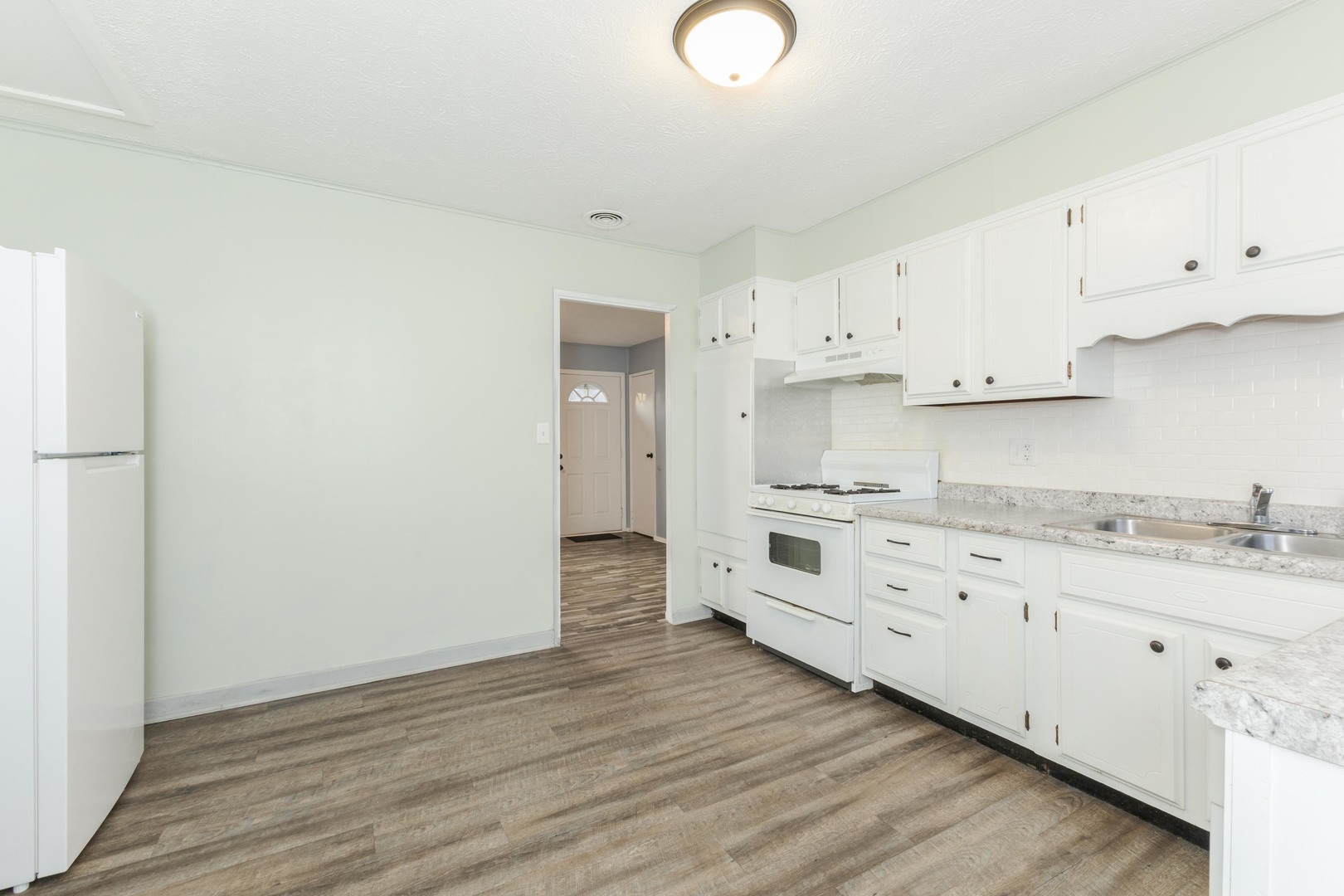 334 East Baker Street Bloomington, IL 61701 - Photo 13 of 32 a kitchen with granite countertop white cabinets and white appliances
