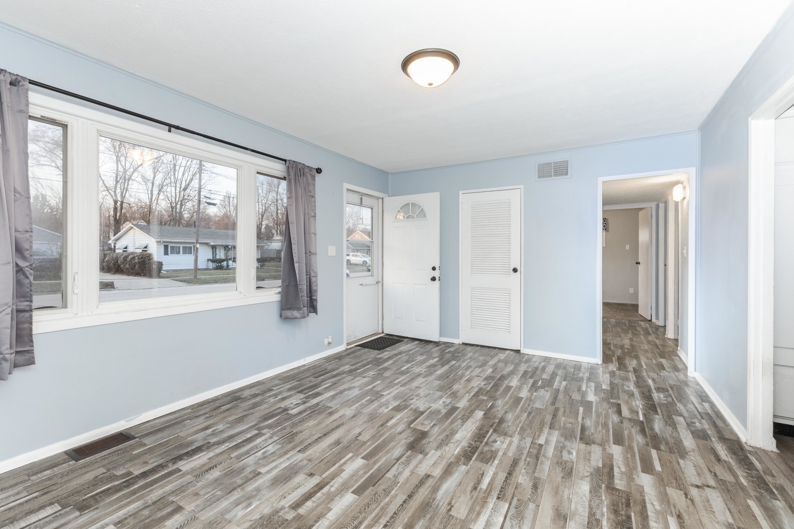 334 East Baker Street Bloomington, IL 61701 - Photo 14 of 32 a view of an empty room with wooden floor and a window