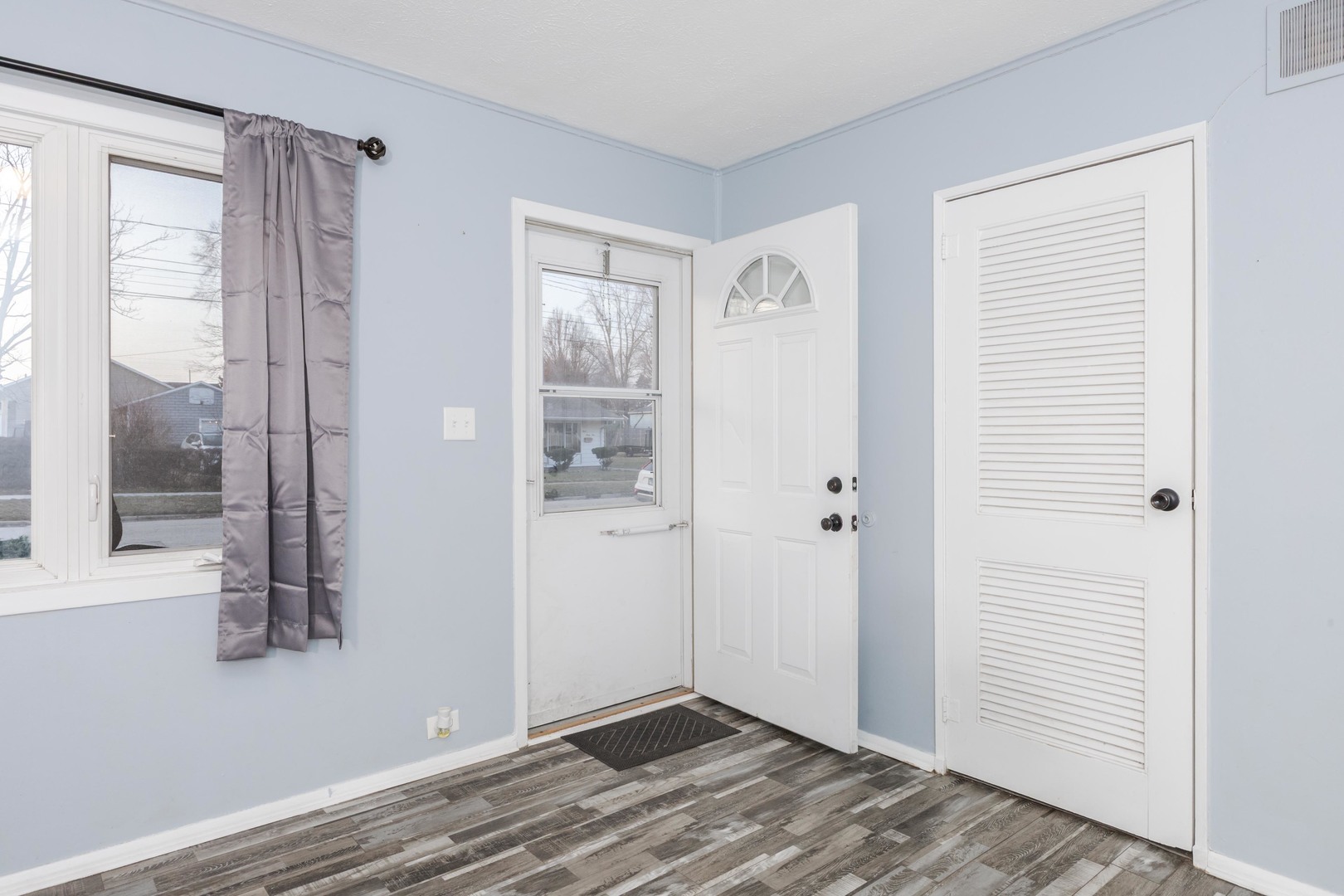 334 East Baker Street Bloomington, IL 61701 - Photo 3 of 32 a view of an empty room with wooden floor and a window
