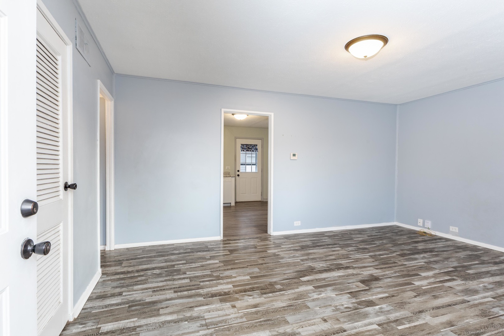 334 East Baker Street Bloomington, IL 61701 - Photo 6 of 32 a view of an empty room with wooden floor and a window