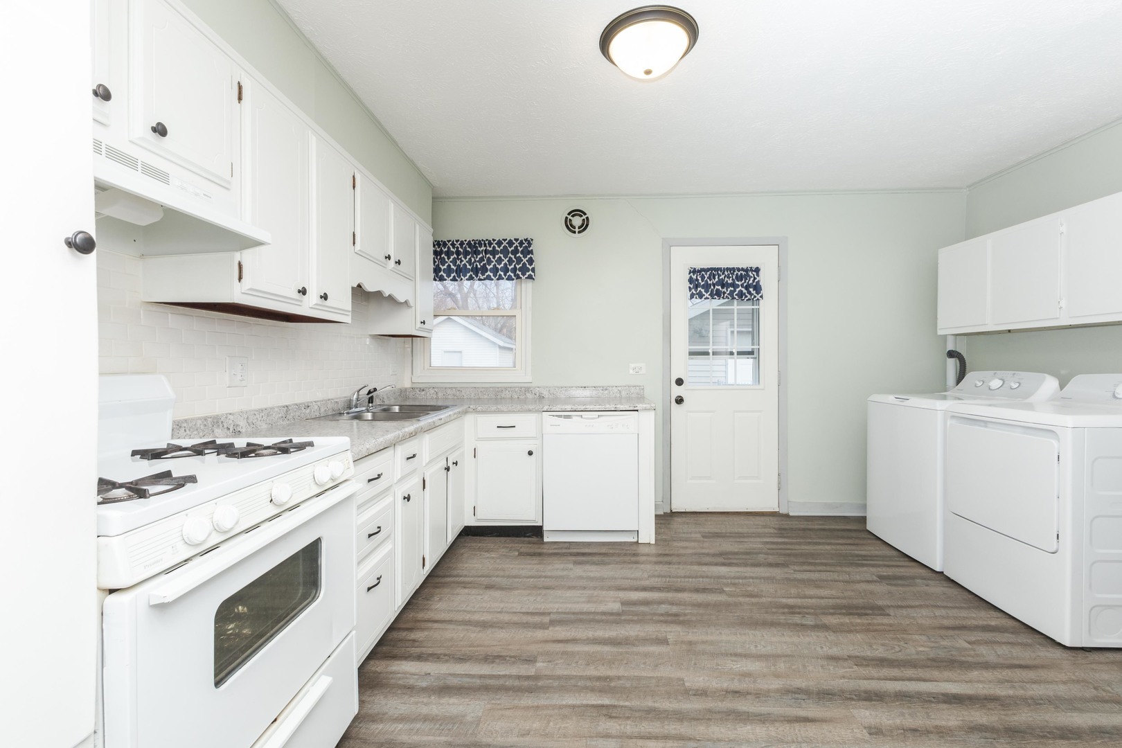334 East Baker Street Bloomington, IL 61701 - Photo 7 of 32 a kitchen with granite countertop white cabinets and white appliances