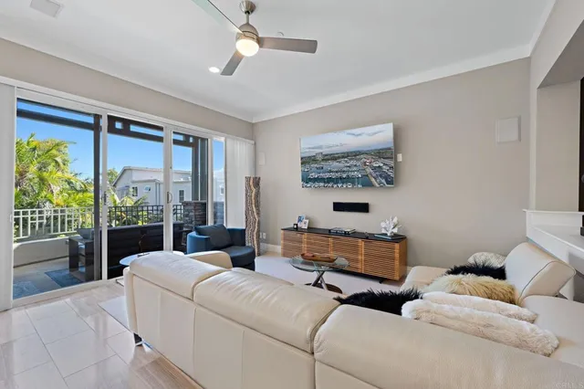 a living room with furniture large windows and a chandelier