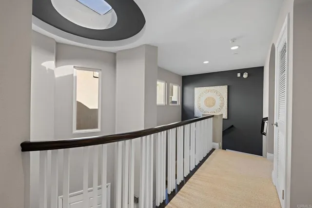 a view of a hallway with wooden floor and a mirror