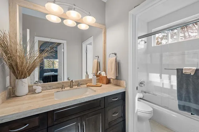 a bathroom with a double vanity sink toilet and a mirror
