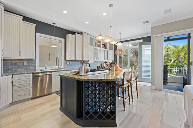 a kitchen with granite countertop a sink appliances and wooden floor