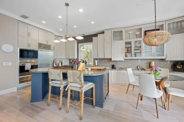 a kitchen with a dining table chairs wooden floor and appliances