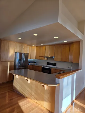 a large kitchen with stainless steel appliances a large counter top stove and a refrigerator