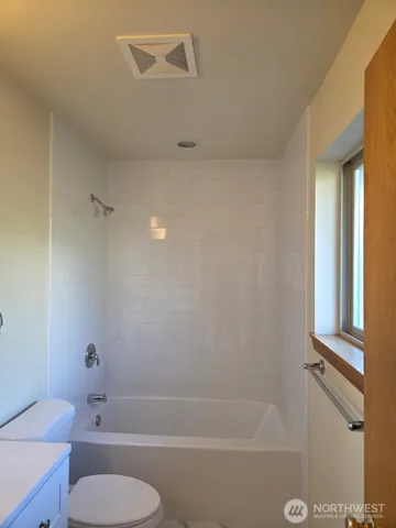 a bathroom with a toilet and a bath tub