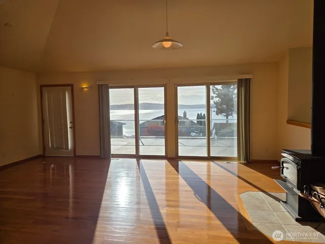 a view of a room with wooden floor and windows