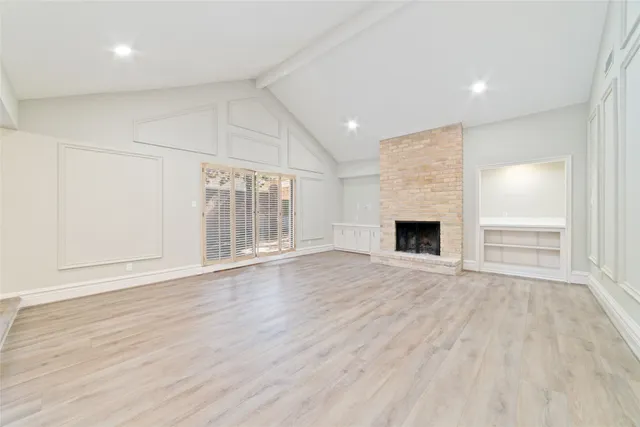an empty room with wooden floor and fireplace