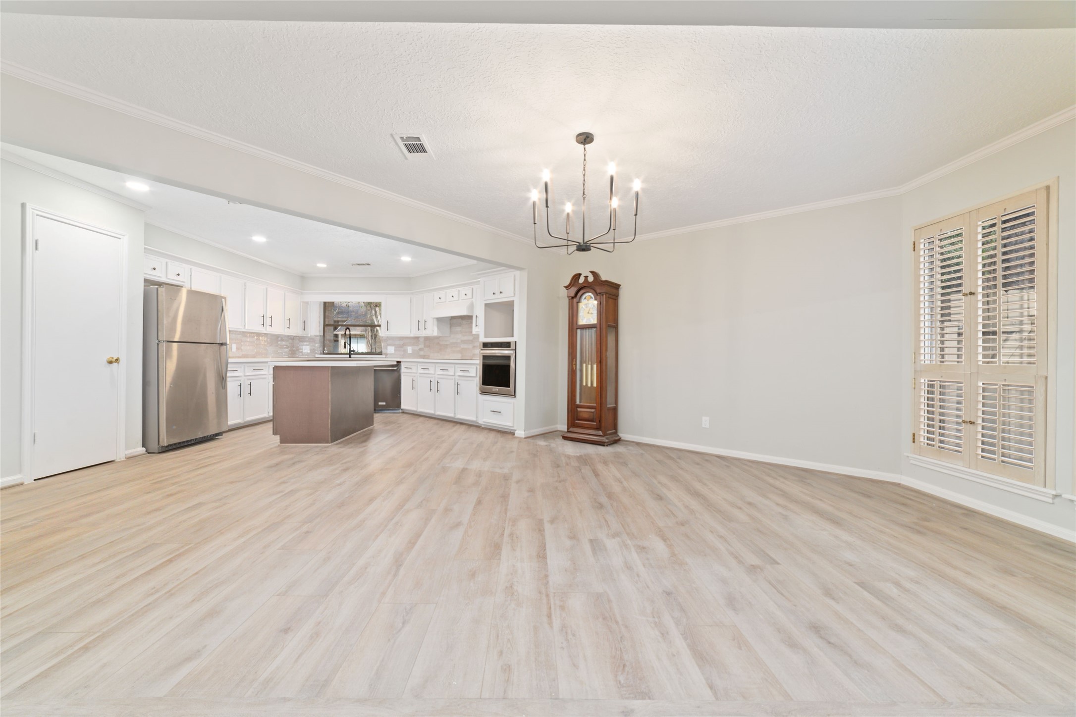 154 Old Bridge Lake Street Houston, TX 77069 - Photo 20 of 30 a view of empty room with wooden floor and kitchen view
