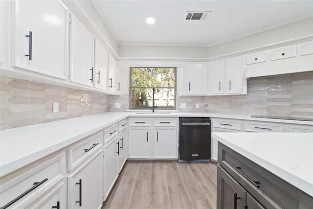 a kitchen with granite countertop white cabinets white stainless steel appliances a sink and dishwasher