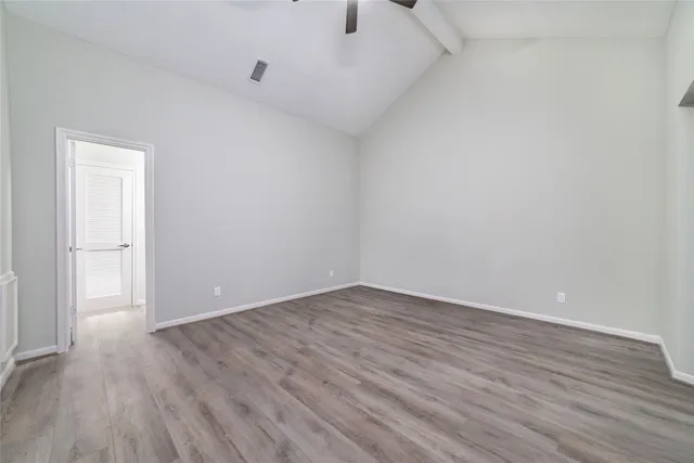 a view of an empty room with wooden floor